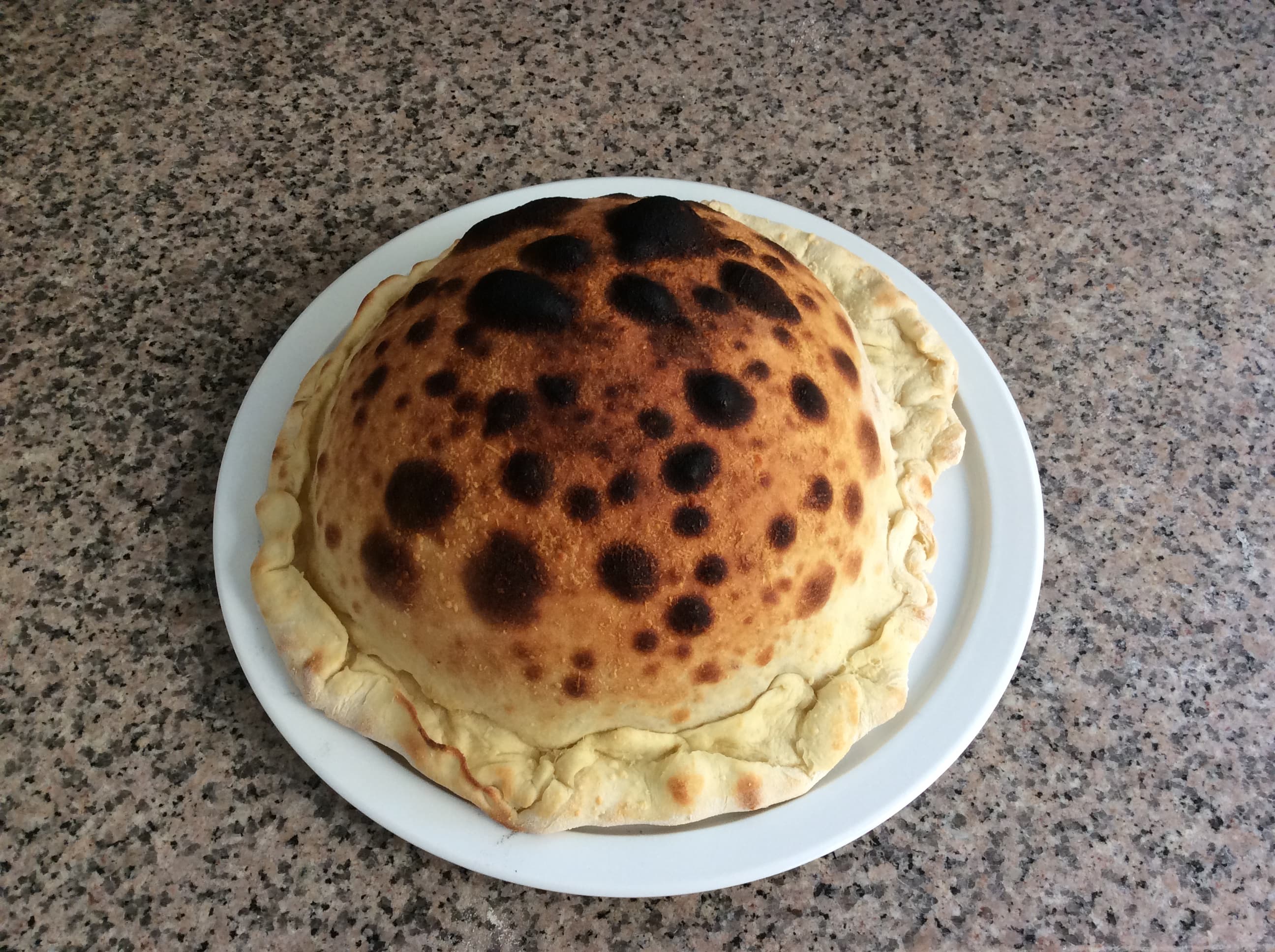 Photo de la calzone du chef, bien bombée et bien dorée.